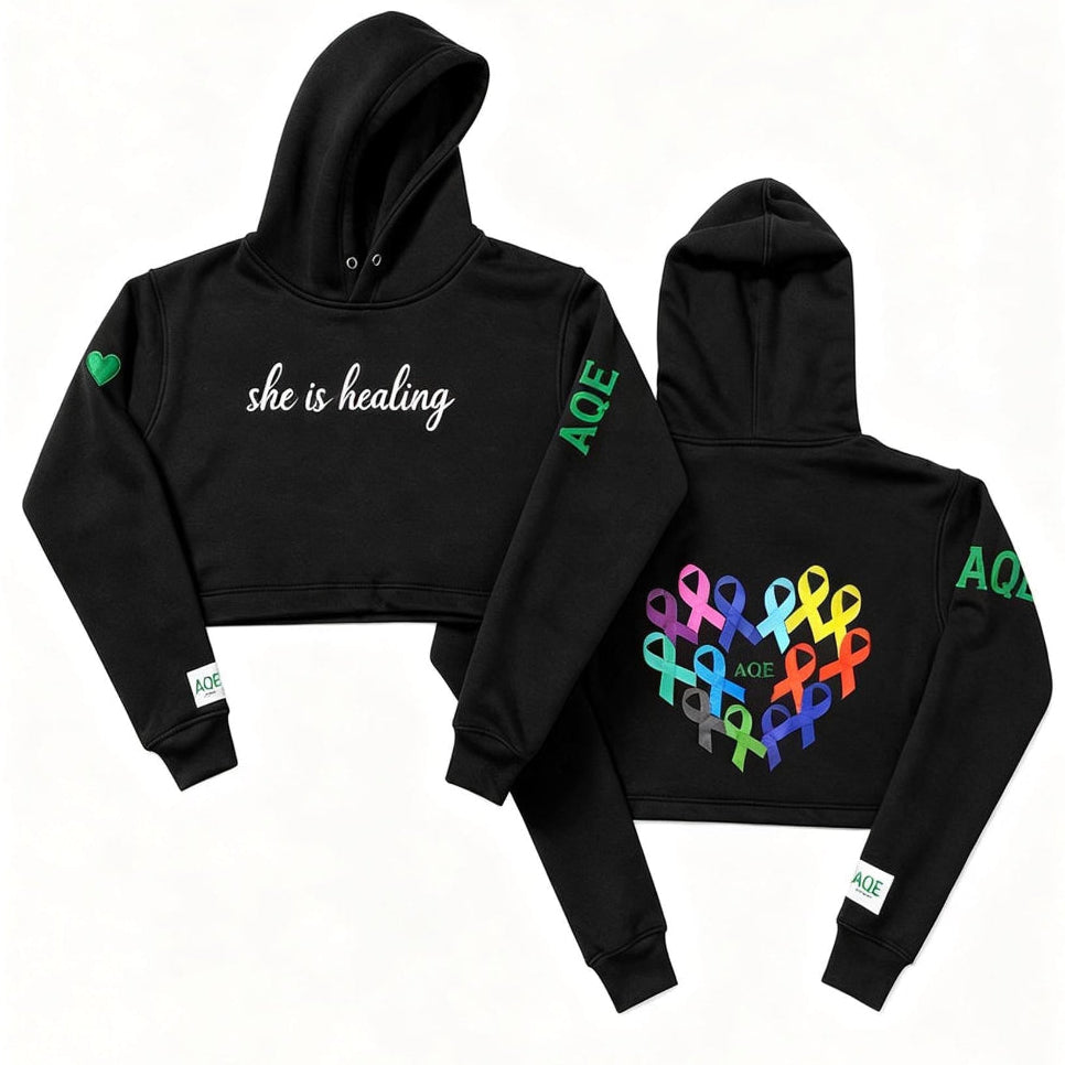 Black hoodie with 'she is healing' text on the front.