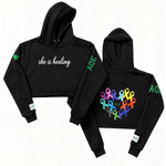 Black hoodie with 'she is healing' text on the front.