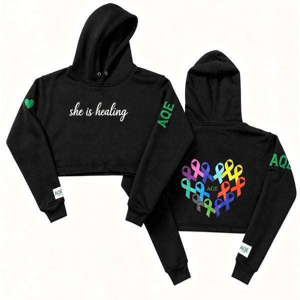 Black hoodie with 'she is healing' text on the front.