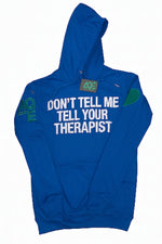 A blue pullover hoodie with a front kangaroo pocket, featuring white text that reads 'DON'T TELL ME TELL YOUR THERAPIST' across the chest, a green heart on the right sleeve, and green 'AQE text on the left sleeve.