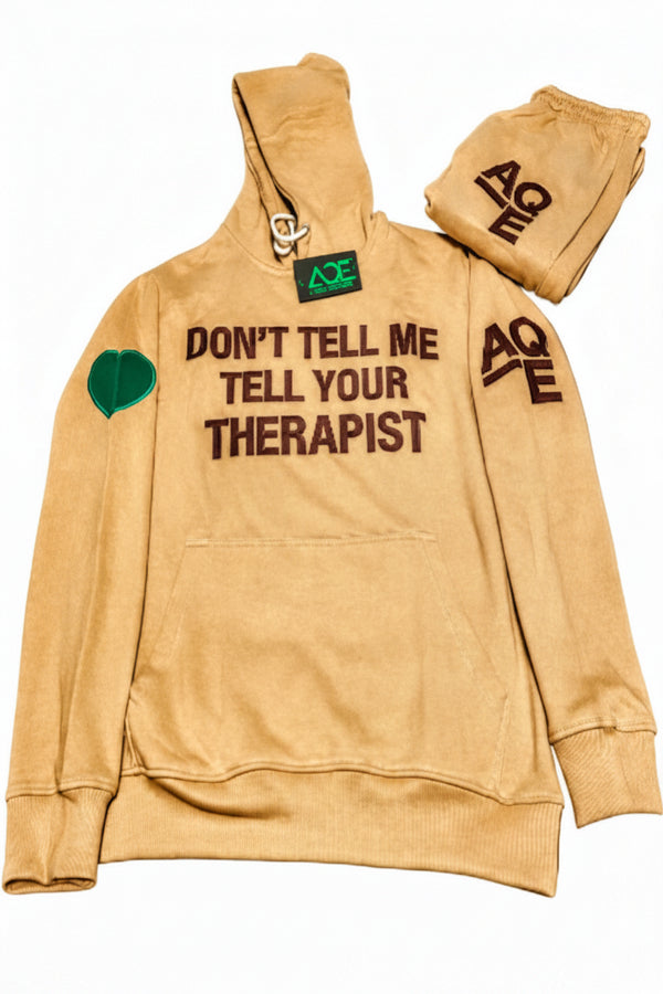 A beige hooded sweatshirt with the text 'DON'T TELL ME TELL YOUR THERAPIST' 