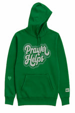 A green pullover hoodie with a front kangaroo pocket and a large 'Prayer Helps' graphic in white and gray on the chest. A small green heart is printed on the left sleeve, and a small white tag is visible on the right sleeve cuff.